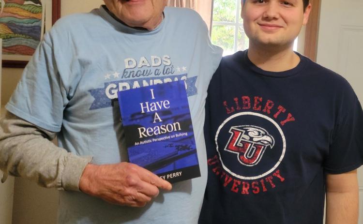 Author Joey Perry, right, presents his grandfather, Lloyd Perry, with a proof copy of his memoir, “I Have a Reason: An Autistic Perspective on Bullying.” Perry will have a book launch and signing Dec. 2, 6-7 pm, at The Farmers Daughter Market. Photo provided.