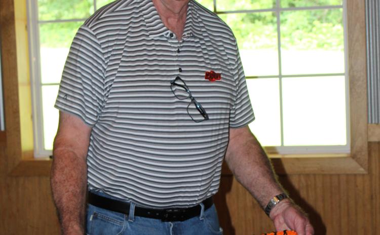 Dr. Bob Evans, DVM, holds up his retirement cake during a reception at Crossing Hearts Ranch on May 21. Evans founded Tecumseh Veterinary Clinic in 1978. Countywide & Sun/Natasha Dunagan