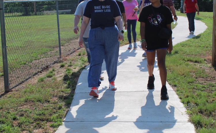 Holly Gordon, of the Gateway to Prevention TSET Healthy Living Program, walks and talks with Adriana Watson, 11, on the new 1/2-mile walking trail at Slick Humphrey Park in Tecumseh on June 8. Gordon also spoke at the TAG meeting held at the park that day. Countywide & Sun/Natasha Dunagan