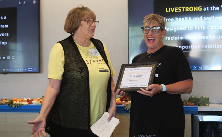The designated “class clown” Gayla Casey, left, makes YMCA Health and Wellness Director LaDawn Hladik laugh with her stories during the Livestrong Program’s first graduation ceremony, held at First United Bank in Shawnee on June 8. Countywide & Sun/Natasha Dunagan
