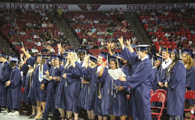 The Shawnee Class of 2023 holds up wolf signs as "Hail, Shawnee High School" is sung by members of the SHS Choir at graduation on May 18. Countywide & Sun/Natasha Dunagan