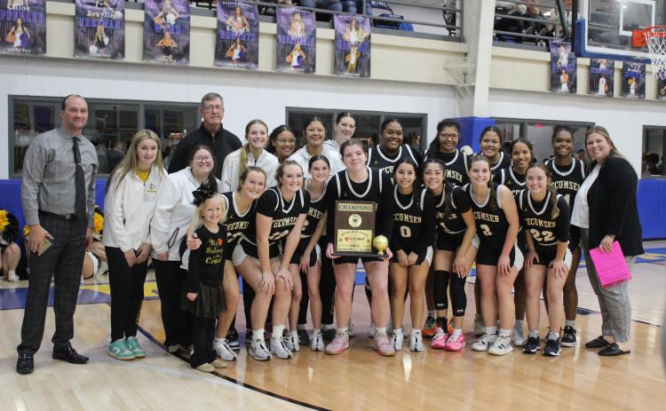 The Tecumseh Lady Savages and their coaches pose with the First United Basketball Classic Girls Champion trophy after beating Bethel, 55-46, on Dec. 9 at the newly remodeled Bethel High School gym. The Lady Savages won all three of their games at the three-day tournament with Perkins-Tryon, Sallisaw and Bethel.