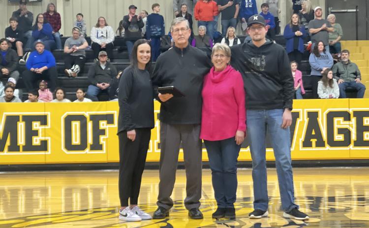 Tecumseh Athletic Director Casi Bays presents a plaque to Assistant Basketball Coach Bill Grogan in honor of his 50 years in coaching on Feb. 14. Also shown are his wife Jenni Grogan and son Todd Grogan. Photo provided by Casi Bays.