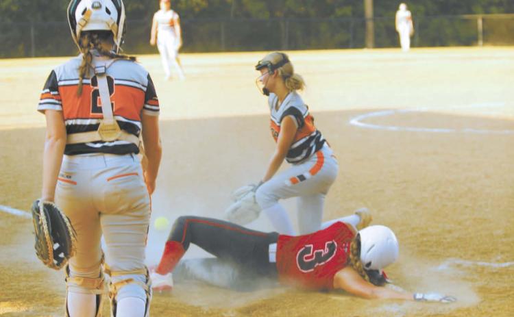 Macomb junior Deja Givens dives across home as Maud senior and pitcher Kylee Collins runs up to tag her during the fast pitch game at Maud on Aug. 8. Also shown is Maud junior and catcher Mariah Burkhalter. Macomb won, 19-6. Natasha Dunagan, Countywide & Sun
