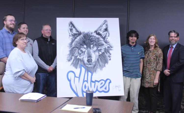Shawnee High School senior Angel Cazares, third from right, painted this wolf to hang in the Shawnee Public Schools Board of Education room the day before the Nov. 3 meeting. Shown, from left, are board members Turner Bass, Mandy Hillhouse, Casey White, Russ Oliver, Cazares, Jeanne Swinney and President Clif Harden. Cazares also did a live painting of a wolf at the Oct. 21 Community Pep Rally. Natasha Dunagan, Countywide & Sun