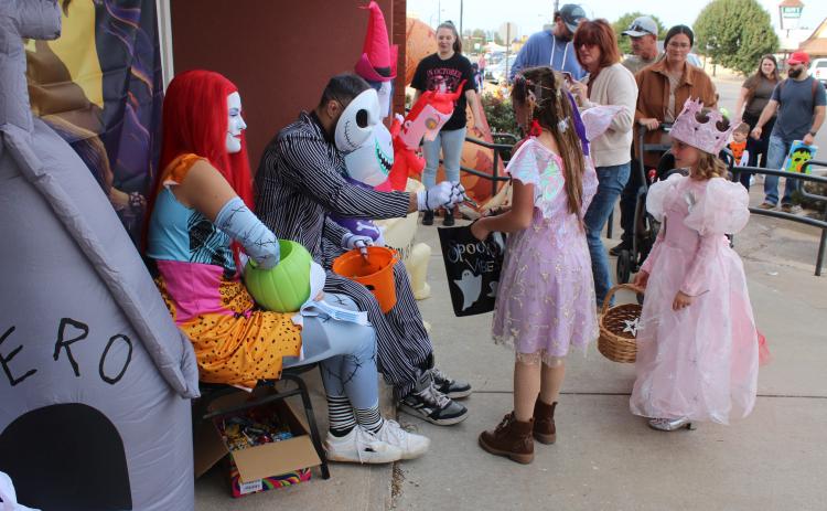 Dressed as characters from "The Nightmare Before Christmas," Maggie and Brian Grinnell with Clarity MMA hand out candy to a fairy and a princess during the Tecumseh Business Treat 'r Treat on Oct. 31.
