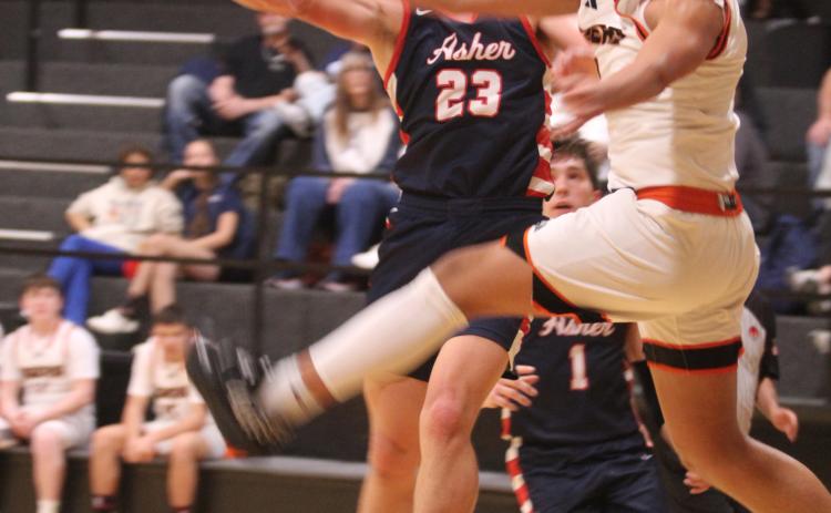 Asher junior Andrew Overstreet keeps his eyes on the hoop, as Maud freshman Koi Street equals his efforts on defense. Natasha Dunagan, Countywide & Sun