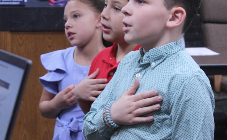 Shawnee students Charlyne Jones, Cordan Jones and Jaxon Wano lead the flag salute to the United States flag during the Feb. 9 Shawnee Board of Education meeting. Natasha Dunagan, Countywide & Sun