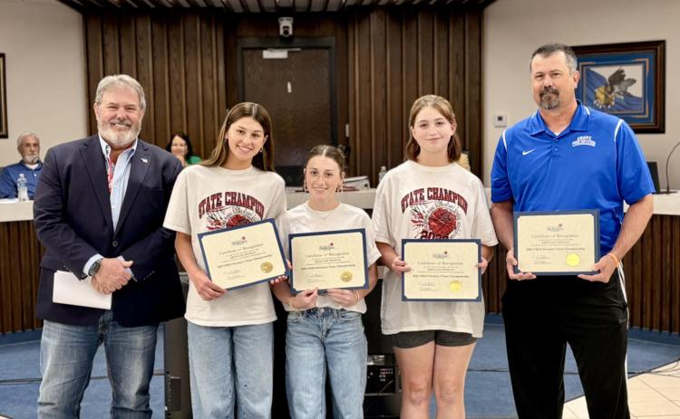 The Shawnee City Commission recognized the Grove Basketball Girls for winning the school's first State Championship. The tournament was hosted by North Rock Creek on Feb. 14. In the first round, they beat Woodall (who had won 14 of the last 16 titles) in the second round, they beat Lone Star, who had beat them twice earlier in the season; they won the Championship game against Marietta 46-22. Shown next to Mayor Eric Stephens is Jacelyn Fichtner, Parker Lilley & Evie Scott with their coach, Chris Pingry.