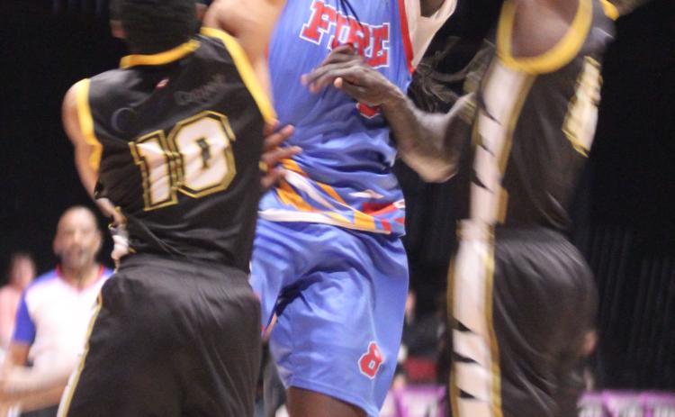 Potawatomi Fire Forward KD Moore fights his way through two CYM Leopards to get to the basket in the third quarter of the March 28 home game. The Fire continued their winning streak with a score of 145-105. Photos by Natasha Dunagan, Countywide & Sun