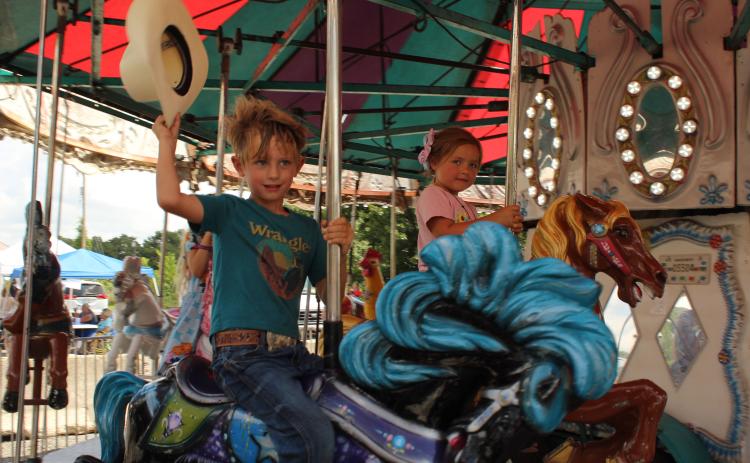 Clyde Hamlin, 5, of Tecumseh, and Callie Luck, 3, of Shawnee, ride on the carousel at the 131st Annual McLoud Blackberry Festival on June 20. The two-day festival also featured vendor booths, live music, kids games and a parade. Photos by Natasha Dunagan, Countywide & Sun