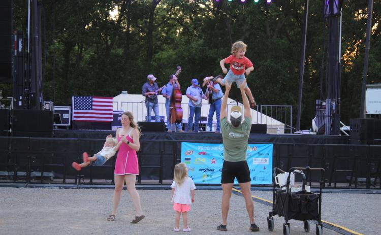 Morgan and Gage Bullard, of Edmond, swing and toss two of their three children, ages 1, 3 and 4, as Oklahoma Line performs "Before I Met You" on Friday night, Aug. 7, during the FireLake Fireflight Balloon Festival. Kaleb Austin and Austin Snell also performed at the festival on Aug. 8 at the CPN Festival Grounds in Shawnee. Photos by Natasha Dunagan, Countywide & Sun