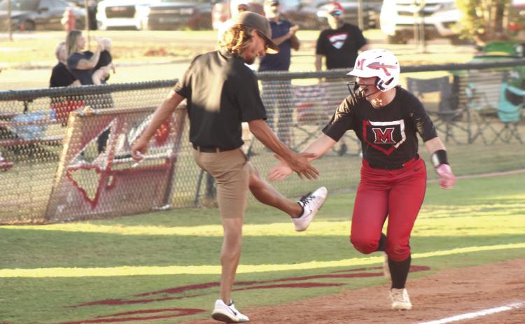 McLoud's Makenzie Lane gets a low five from Head Coach Garrett Hannah after crossing third base on her way to a home run in the Sept. 22 home game against Tecumseh. The Lady Redskins won, 14-4, and have a record of 25-9 so far. Natasha Dunagan, Countywide &amp; Sun
