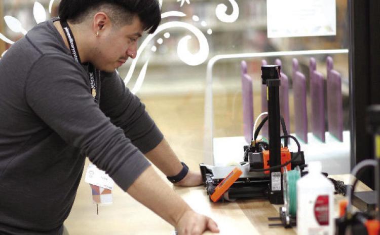 A staff member sets up a new 3D printer in the Shawnee Public Library’s Maker Lab. Photo provided.