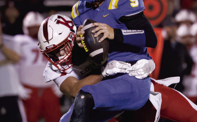 Right: Bethel senior Maddox Davis is caught before he's able to pass the ball during the home game against Kiefer on Oct. 2. The Wildcats lost, 12-63. Photos courtesy of Richelle Treece