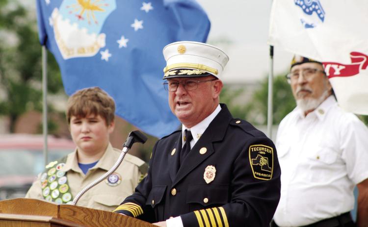 Tecumseh Fire Chief and former U.S. Navy BU3 Rhett Banks speaks about a friend who lost his life in Iraq during the Memorial Day service at Tecumseh Cemetery on May 29. Listening behind him are Scout Robby Byrd, 13, and American Legion Post 260 Adjutant William Gammage. Countywide &amp; Sun/Natasha Dunagan