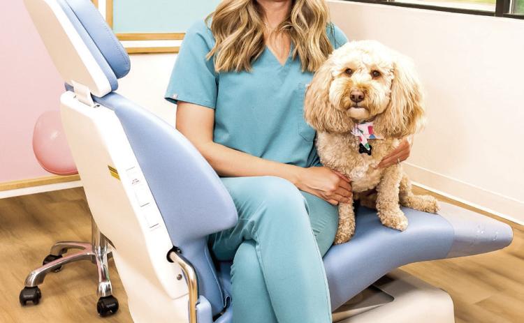 Dr. Sarah Karnish poses with her therapy dog Teddy at Shawnee Pediatric Dentistry. Karnish was nominated as one of Pottawatomie County's Inspiring Women. Photo provided