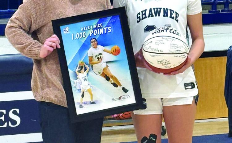 Coach Wendi Wells presents Shawnee senior Daley Rice with a framed photo and a game ball in recognition of Rice reaching 1,000 high school career points in January. Photo provided by Shawnee Public Schools