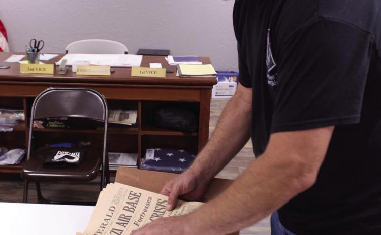 American Legion Post 16 Past Commander Keith DiPatri shows one of the many historic newspapers which have been donated to the post's collection. Several documents, photographs and military items have been preserved and displayed since the April 2023 tornado. Photos by Natasha Dunagan, Countywide &amp; Sun