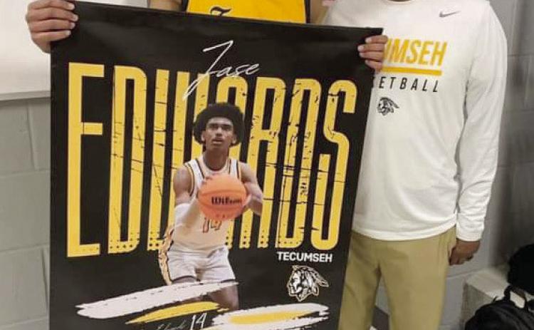 Tecumseh senior Jase Edwards, with his father and coach Bryant Edwards, pose with his banner after the shooting guard reached 1,000 career points last month. Photo provided.