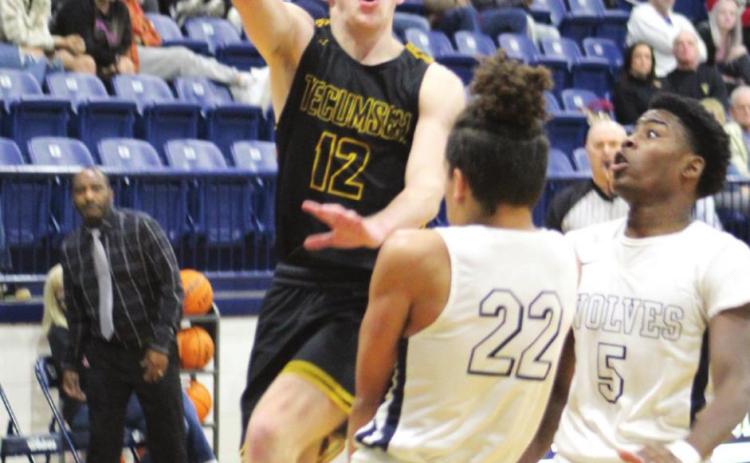 Tecumseh’s Ben Corley scores two points over Shawnee’s Jalen Wicks (#22) and T.J. Bishop (#5) during the third quarter of the game at Shawnee on Jan. 14. Corley made nine points in that quarter and 21 points for the game.