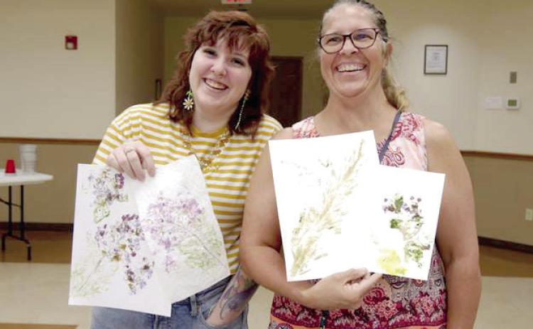 Library customers show off the flower art they created at the Tecumseh Public Library. Photo provided.