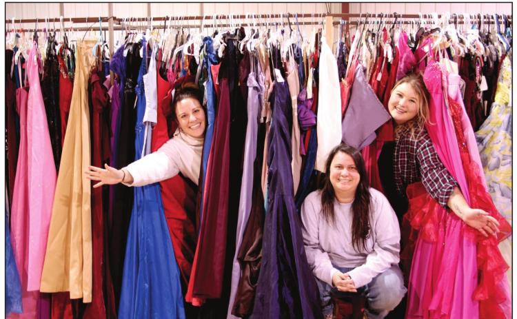 Say Yes To The Prom Dress event coordinators Jessica Hernandez, Okie Dokie Mercantile &amp; Co’s Christina Hernandez, and Cassie Low hide among racks of dresses they were sorting in preparation for the event. The pop up dress closet will provide high school students with approximately 1,500 free dresses to choose from for prom, during the three day event, March 18-20. Countywide &amp; Sun/Kendra Johnson