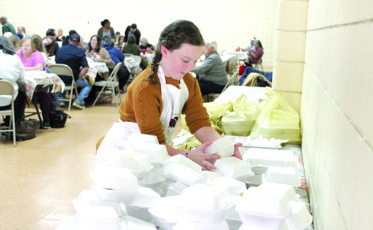 Taycie Baker stacks up boxed slices of pie for to-go meals at the 18th Annual Tecumseh Family Thanksgiving Dinner at Tecumseh City Hall Auditorium. Event organizer and Baker’s grandmother Suzanne Gilbert said they gave out 625 to-go dinners and 500 dine-in meals for a total of 1,125 this year. Countywide & Sun/Natasha Dunagan