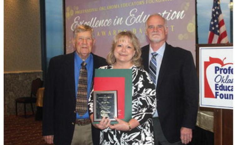 Tecumseh art teacher Jennifer Cox poses after receiving the Professional Oklahoma Educators Foundation High School Educator Merit Award on April 19. Shown with her are, left, Bill Bentley, Chairman of the POE Foundation Board, and right, Tony Hutchinson, President of the POE Board of Directors. Photo provided.