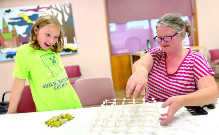 Program attendees test their toothpick structure at the Shawnee Public Library. (Photo provided.)