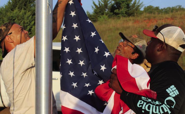 Shawn Edwards, Franklin Edwards and Clarence Bernard attach the U.S. flag to hoist it for the first time on a newly installed 25-foot flagpole at the Brooksville town limits, June 28. File photo