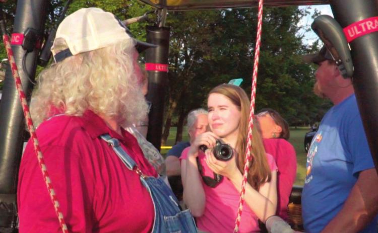 Countywide & Sun journalist Kendra Johnson stands in a tethered hot-air balloon, while talking with the balloon’s pilot and taking pictures, during the FireLake FireFlight Balloon Festival last year. Photo provided by Ronald Johnson.