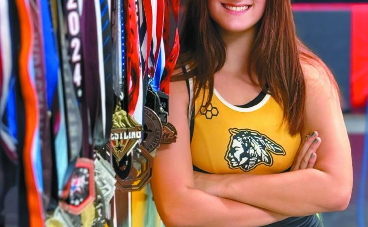 Kylei Gokey poses for a professional photo in her Tecumseh High School singlet and with the 35 medals she's won so far. Gokey has been wrestling since seventh grade and will go into her sophomore year, having been a state-qualifier as a freshman and having competed at national tournaments in Fargo, ND, and Westfield, IN, over the summer. Photo provided