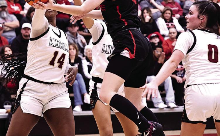 North Rock Creek's Addisen Lawrence drives between three Lincoln Christian defenders. NRC ladies tip off tonight at 6 in Hennessey. Photo courtesy of Gowin Photography