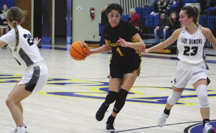 Tecumseh’s Serenity Jacoway dribbles between two Perkins-Tryon players on her way to the basket during the First United Bank Classic consolation championship round in Bethel on Dec. 11. The Lady Savages won that game, 39-35. They lost to Byng in the first round on Dec. 9, 37-54, and won against Bridge Creek, Dec. 10, 74-32. Countywide &amp; Sun/Natasha Dunagan
