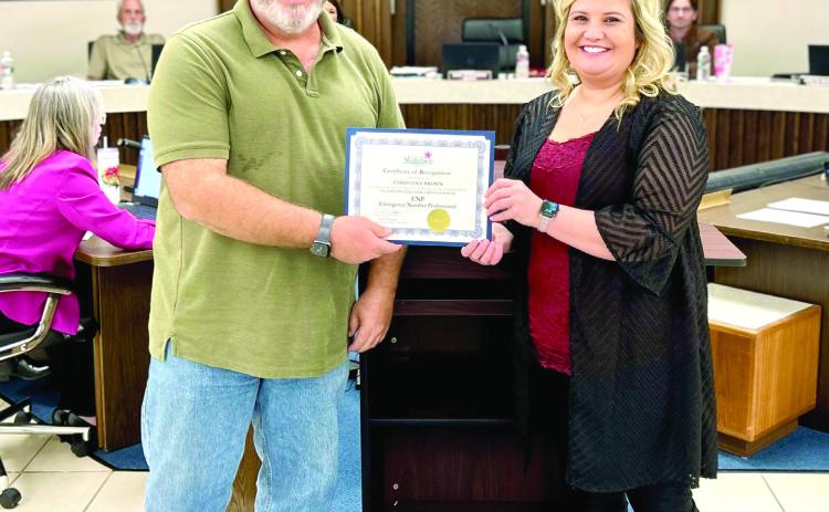 During the Shawnee Board of City Commissioners meeting held Monday, Oct. 21, Mayor Eric Stephens presented a Certi_cate of Recognition to Shawnee Police Department’s Communication Manager Christina Brown (right) for receiving the Emergency Number Professional Certi_cation. Photo provided