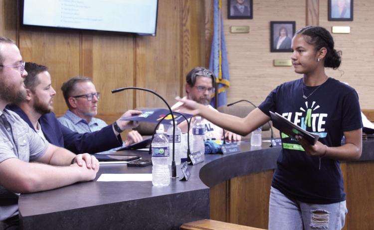 Shawnee High School sophomore Khloe Tungate hands out literature on the Elevate Student Health Campaign to the Shawnee Public Schools Board of Education at their Oct. 6 meeting. Natasha Dunagan, Countywide &amp; Sun
