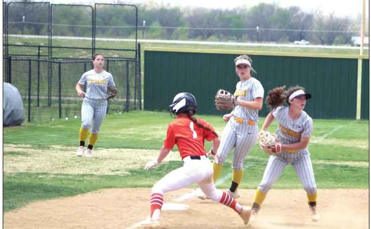 Tecumseh freshman and pitcher Jessi Hull, far right, tags a runner out at third base and turns to throw it to a teammate, as Katelyn Fleming, center, guards her base during the Dale Slowpitch Festival game against Sterling on April 15 at the FireLake Ball Fields.The Lady Savages won in the fourth inning, 10-0. Countywide &amp; Sun/Natasha Dunagan