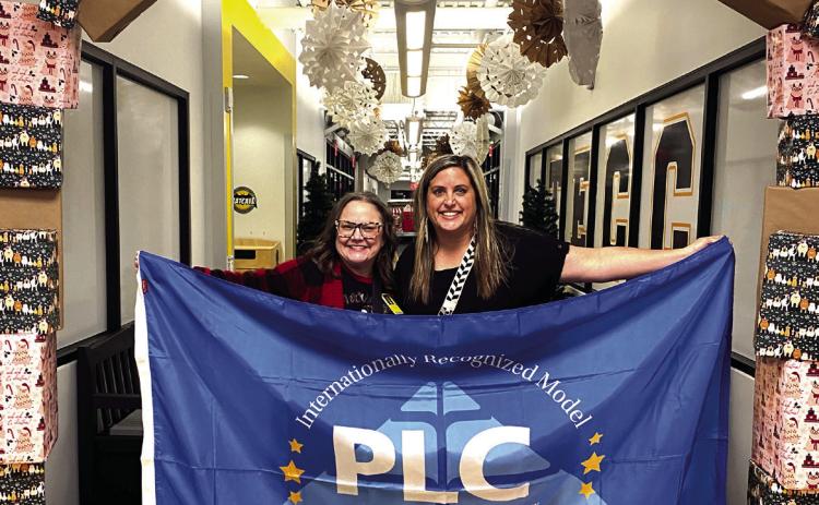 Tammy Giaudrone, Principal at Tecumseh Early Childhood Center, and Ashley Steward, Intervention Specialist proudly display the flag they were awarded last month to represent their achievement as a Professional Learning Community award recipient. Julie Talton, Countywide & Sun