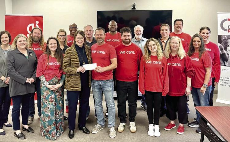 Kathy Laster, Ph.D. President &amp; CEO Avedis Foundation, presents a check to Community Renewal Executive Director Brandon Dyer while staff and Avedis board members join in for the presentation. Photo provided