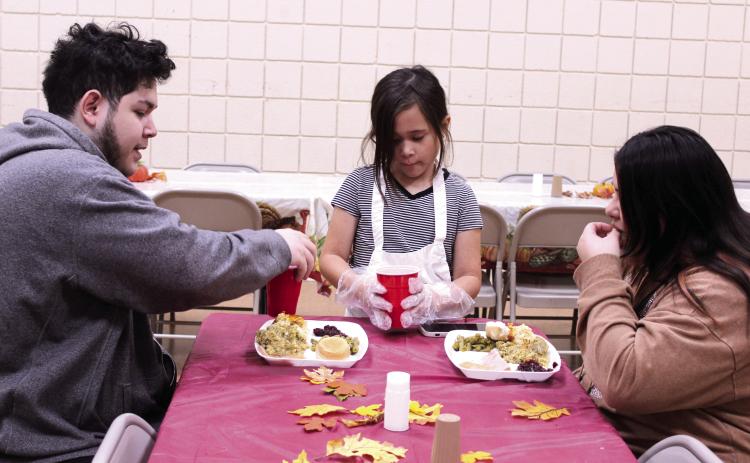 Madisyn Castaneda, 10, serves drinks to Jimmy and Unity Alas of Maud during the 20th Anniversary Tecumseh Family Thanksgiving Dinner, held at the Tecumseh City Hall Auditorium on Nov. 27. U. Alas said she used to come to the dinner with her father and grandmother, and decided to introduce her husband to it this year. Castaneda was volunteering for the first time with her two sisters and her parents, Daniel and Amber Castaneda. Natasha Dunagan, Countywide & Sun