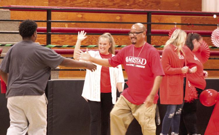 Earlsboro High School student Steven Winn gets high fives from school staff members Chris McKinney and Amanda Elmore after joining the Amistad House during the Sorting Ceremony on Sept. 2. In the past, Earlsboro held a sorting ceremony for the elementary students, but this year, it includes all of their students and follows the Ron Clark Academy. Natasha Dunagan, Countywide &amp; Sun