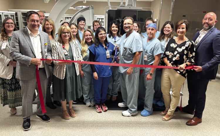 SSM Health Saints Heart Cardiologists Isma Javed, MD, and Troy Norred, MD are surrounded by hospital administrators and Cardiac Cath Lab staff as they prepare to cut the ribbon on the new Cath Lab. Photo provided