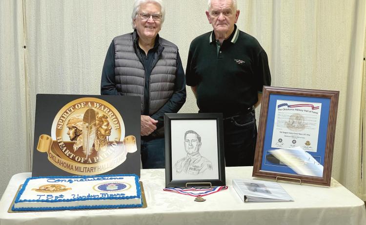 Dr. James Myers, of Tulsa, and Skip Myers, of Tecumseh, pose by a portrait of their father, Tech Sergeant Verdun C. Myers, following a ceremony in which the late WWII veteran was inducted into the Oklahoma Military Hall of Fame. The ceremony was held at American Legion Post 16, in Shawnee, on Dec. 21. Photo provided by OKMHF Ambassador John Farris.