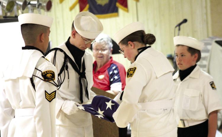 The Naval Sea Cadet Color Guard demonstrattes the folding of the U.S. flag, as Sea Cadet Director Donna Snodgrass reads their meanings during the Tecumseh American Legion Post #260 Flag Day Ceremony on June 14. The Color Guard is, from left, Kenneth Irwin, Zachary Hastings, Diana Murray and Daryl Murray. Natasha Dunagan, Countywide &amp; Sun