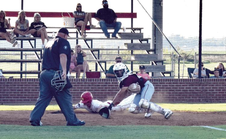 Dale's Andrew Collins slides across home plate ahead of the ball to score for the Pirates.