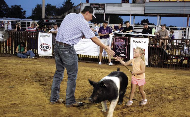Tecumseh 4-H member Tatum Davis shakes hands with livestock judge Garret Wellden after showing her Hampshire hog during the T-Town Showdown on Aug. 22 at the Tecumseh Roundup Club. Photos by Natasha Dunagan, Countywide &amp; Sun