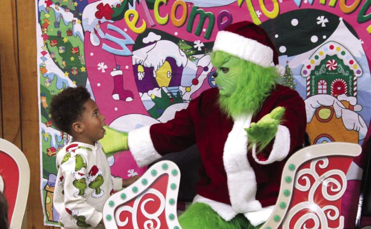 Trevion Mucker, Jr., 4, of Shawnee, is surprised after the Grinch gave him a hug during the First Annual Grinch-Fast, held at the Veterans of Foreign Wars in Shawnee on Nov. 29. This was a fundraiser for the Pott. County Giving Project, which has 618 children and adults with disabilities on their Christmas list this year. Natasha Dunagan, Countywide & Sun
