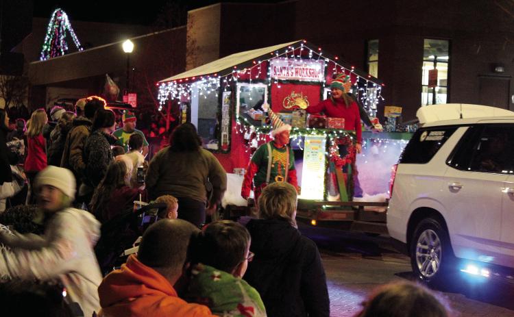 Volunteers and employees of Emergency Management of Pottawatomie County ride on or walk beside their Santa’s Workshop float in the Shawnee Christmas Parade on Dec. 8. Countywide & Sun/Natasha Dunagan