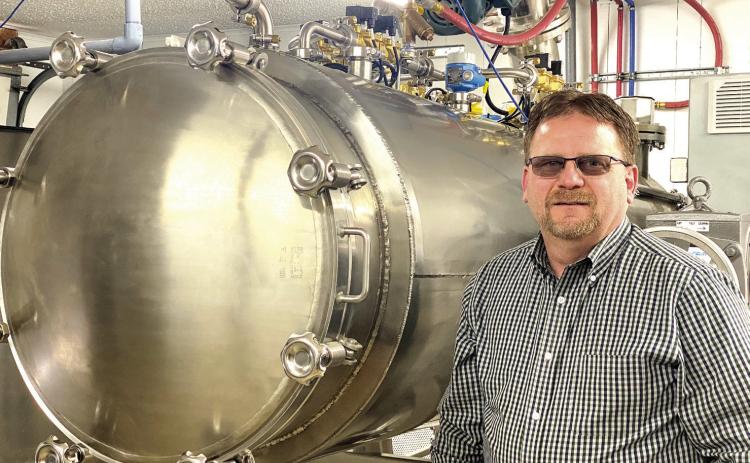 Mike McElyea, Co-Owner, Funeral Director, and Memorial Care Specialist stands next to the newly installed Aquamation machine. He said you can have a normal conversation while this equipment is running. Countywide &amp; Sun/Suzie Campbell